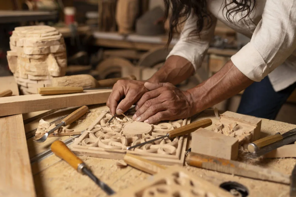Artisan carving intricate detail into wood
