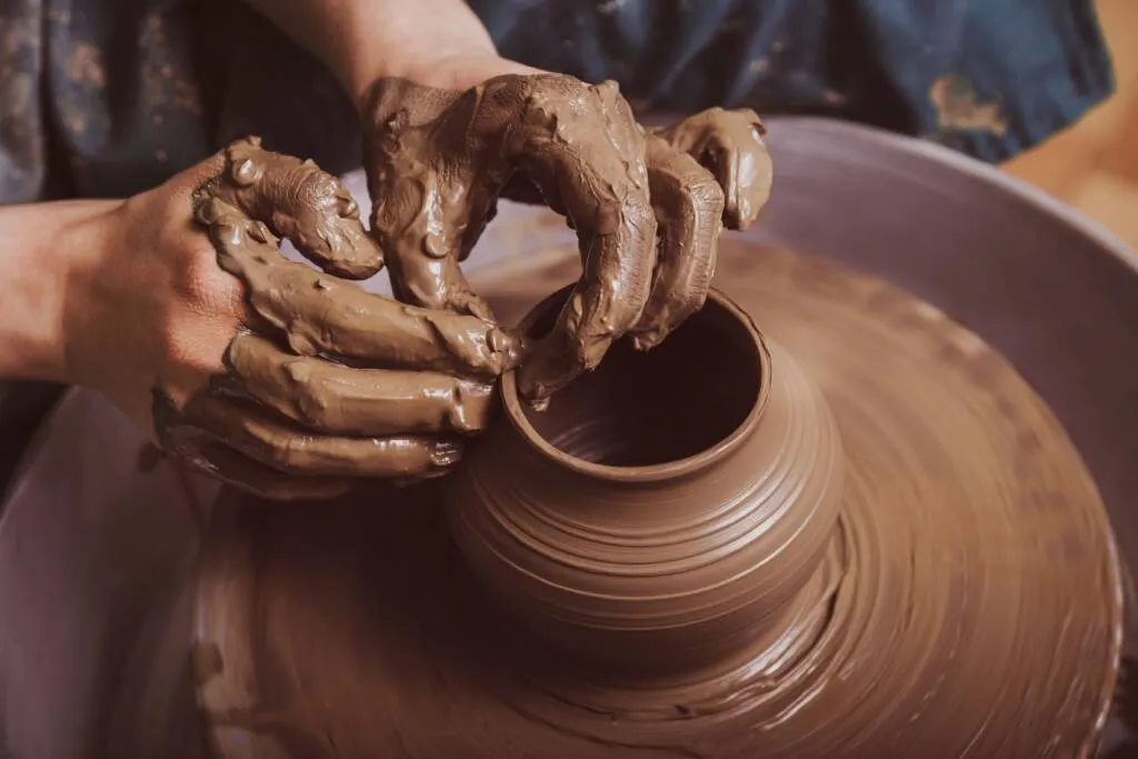Potter’s hands forming a vessel on the wheel